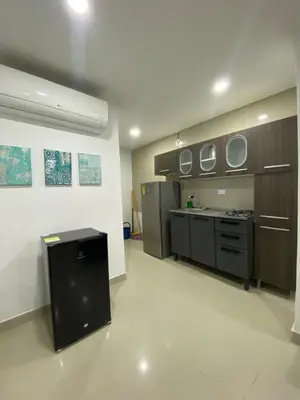 a large kitchen with brown cabinets and a counter top at Apartamento 9 pax En Cartagena in Cartagena de Indias