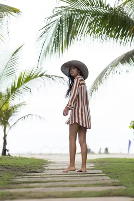 a woman wearing a hat standing under a palm tree at 224 - Morros Epic Acceso Directo a Playa in Cartagena de Indias