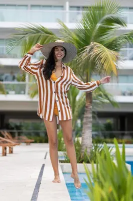 a woman wearing a hat standing next to a pool at 224 - Morros Epic Acceso Directo a Playa in Cartagena de Indias
