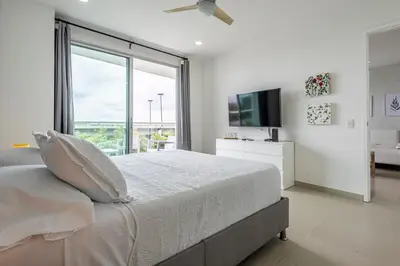 a white bedroom with a large bed and a large window at 224 - Morros Epic Acceso Directo a Playa in Cartagena de Indias