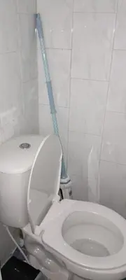 a bathroom with a white toilet and a blue mop at apartamento 3 habitaciones totalmente equipado in Cartagena de Indias