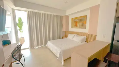 a bedroom with a bed and a desk and a window at Charming Oceanfront Apartment with Balcony and Panoramic view, Cartagena Colombia in Cartagena de Indias