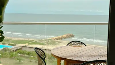 a balcony with a table and chairs and the beach at Charming Oceanfront Apartment with Balcony and Panoramic view, Cartagena Colombia in Cartagena de Indias