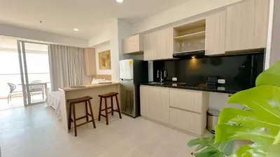 a kitchen with a refrigerator and a counter with stools at Charming Oceanfront Apartment with Balcony and Panoramic view, Cartagena Colombia in Cartagena de Indias