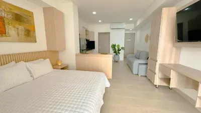 a bedroom with a bed and a living room at Charming Oceanfront Apartment with Balcony and Panoramic view, Cartagena Colombia in Cartagena de Indias