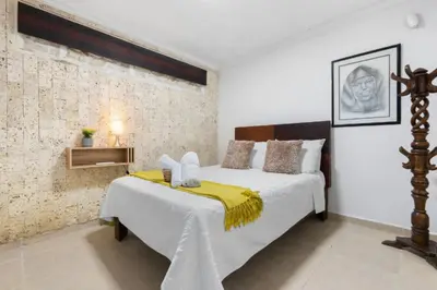 a bedroom with a bed with a yellow blanket on it at Casa Mary Hotel in Cartagena de Indias