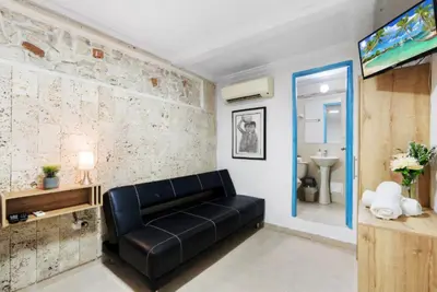 a living room with a black leather couch and a bathroom at Casa Mary Hotel in Cartagena de Indias