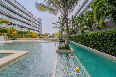 a swimming pool with a palm tree in front of a building at Apartaestudio con Jacuzzi Privado y Vista al Mar in Cartagena de Indias