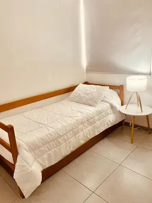 a bedroom with a bed and a lamp and a table at Enjoy the sun and beach in our apartment in Cartagena de Indias