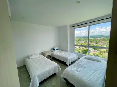 two beds in a room with a large window at Apto espectacular frente al mar in Coveñas