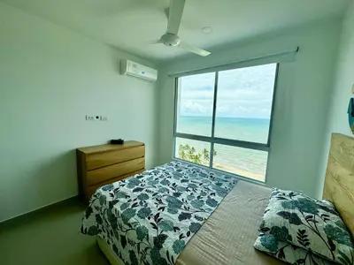 a bedroom with a bed and a large window with the ocean at Apto espectacular frente al mar in Coveñas
