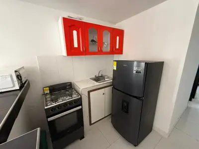 a small kitchen with a black refrigerator and a sink at Apartamento Montecristo in Barranquilla
