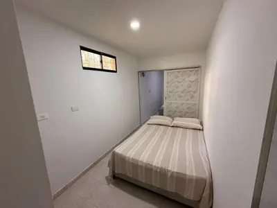 a small bed in a white room with a window at Apartamento Montecristo in Barranquilla