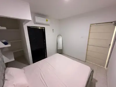 a small bedroom with a white bed and a black door at Apartamento Montecristo in Barranquilla