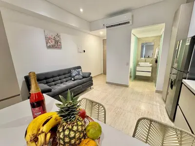 a kitchen and a living room with a table with a pineapple at Loft Vistas Mar. Crespo Piscina y Jacuzzi in Cartagena de Indias