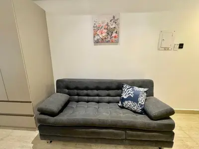 a couch sitting in a living room with at Loft Vistas Mar. Crespo Piscina y Jacuzzi in Cartagena de Indias