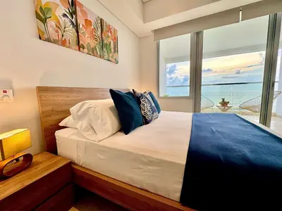 a bedroom with a bed with a view of the ocean at Loft Vistas Mar. Crespo Piscina y Jacuzzi in Cartagena de Indias