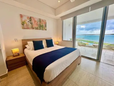 a bedroom with a bed with a view of the ocean at Loft Vistas Mar. Crespo Piscina y Jacuzzi in Cartagena de Indias