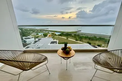 a room with two chairs and a table and a large window at Loft Vistas Mar. Crespo Piscina in Cartagena de Indias