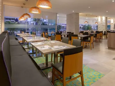 a dining room with tables and chairs in a restaurant at Apto con playa, hotel y piscina in Santa Marta