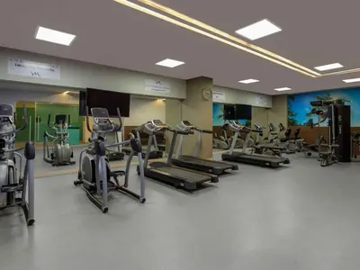 a gym with several treadmills and elliptical machines at Apto con playa, hotel y piscina in Santa Marta