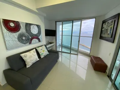 a living room with a couch and a large window at Apartamento Palmetto Eliptic 23 ICDI in Cartagena de Indias