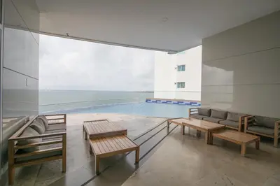 a swimming pool with benches and tables in a building at Apartamento Palmetto Eliptic 23 ICDI in Cartagena de Indias