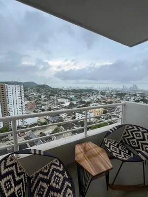 a balcony with two chairs and a view of a city at Alma Kalamari 24 in Cartagena de Indias