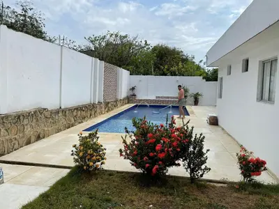 a man is standing next to a swimming pool at Espectacular casa, vista al mar y piscina privada in Santa Veronica