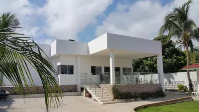 a white house with stairs and palm trees at Espectacular casa, vista al mar y piscina privada in Santa Veronica