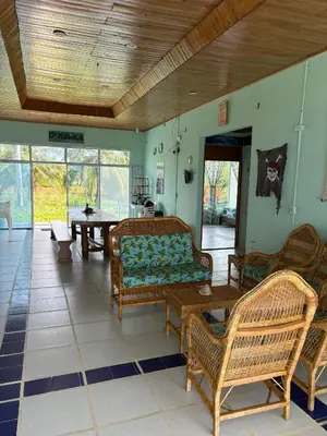 a living room with chairs and a couch and tables at San Bernardo del Viento Cabaña La Isabela in San Bernardo del Viento