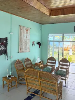 a living room with wicker chairs and a table at San Bernardo del Viento Cabaña La Isabela in San Bernardo del Viento