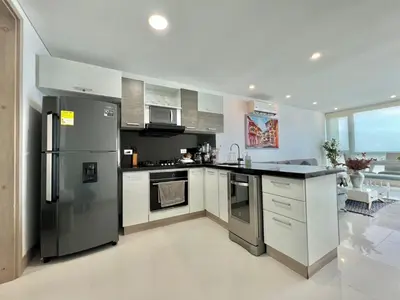 a kitchen with a stainless steel refrigerator and white cabinets at Oceanview Bocagrande Laguito Palmetto Sunset Building in Cartagena de Indias
