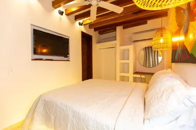 a bedroom with a bed and a flat screen tv at Casa Bali Castillo View Private Pool & Rooftop, Near Historic Center in Cartagena de Indias
