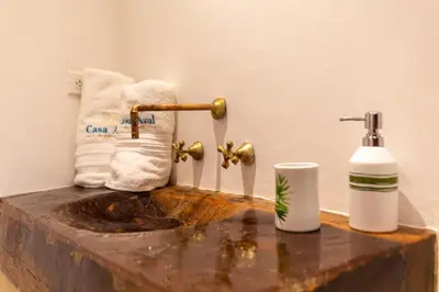 a bathroom with a sink and a toilet paper dispenser at Blue House Castillo View Private Jacuzzi & Colonial Balconies in Cartagena de Indias