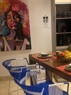 a dining room table with chairs and a painting of a woman at Blue House Castillo View Private Jacuzzi & Colonial Balconies in Cartagena de Indias