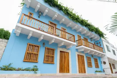 a blue house with wooden windows and a balcony at Blue House Castillo View Private Jacuzzi & Colonial Balconies in Cartagena de Indias