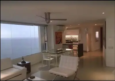 a living room with a glass table and white chairs at Vista Divisadero 25 in Cartagena de Indias