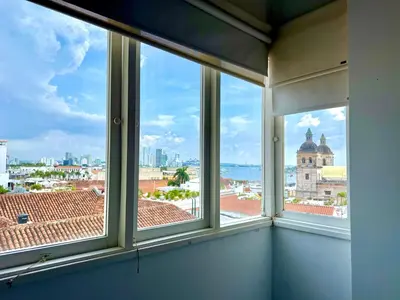 a room with three windows with a view of the city at by Calamari Homes-Plaza Bolivar Penthouse Sea view in Cartagena de Indias
