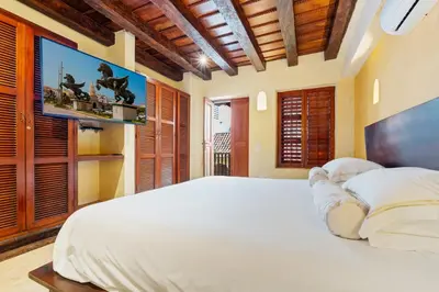 a bedroom with a large bed with a tv on the wall at Reve hotel in Cartagena de Indias