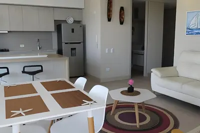 a living room with a table and a kitchen at Exclusivo apartamento en Cielo Mar - Américas 609 in Cartagena de Indias