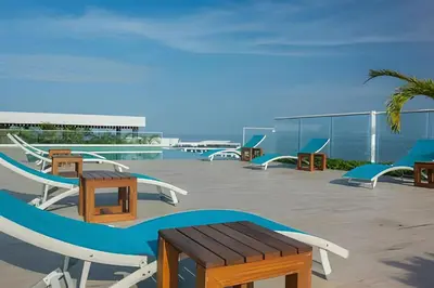 a patio with tables and chairs on a roof at Exclusivo apartamento en Cielo Mar - Américas 609 in Cartagena de Indias