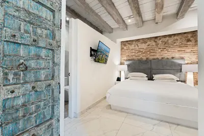 a bedroom with a bed and a brick wall at Upper Hotel in Cartagena de Indias