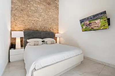 a bedroom with a white bed and a painting on the wall at Upper Hotel in Cartagena de Indias