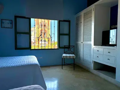 a bedroom with a bed and a stained glass window at by Calamari Homes - El Porvenir 402 walled city in Cartagena de Indias