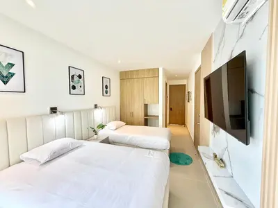 two beds in a hotel room with a flat screen tv at Baia Krystal P4, 1A in Cartagena de Indias
