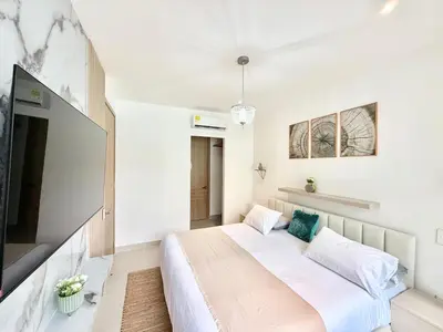 a bedroom with a large bed and a flat screen tv at Baia Krystal P4, 1A in Cartagena de Indias