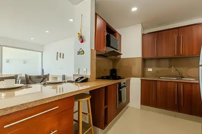 a kitchen with wooden cabinets and a counter top at Espectacular vista al mar - Edificio Infinito 1002 in Cartagena de Indias