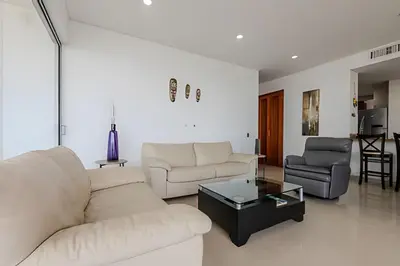 a living room with a white couch and two chairs at Espectacular vista al mar - Edificio Infinito 1002 in Cartagena de Indias