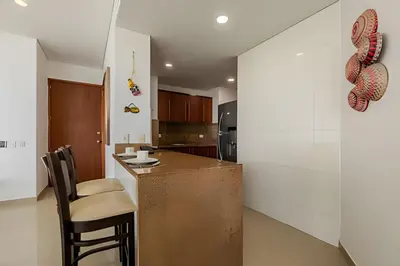 a kitchen with a counter and chairs in a room at Espectacular vista al mar - Edificio Infinito 1002 in Cartagena de Indias